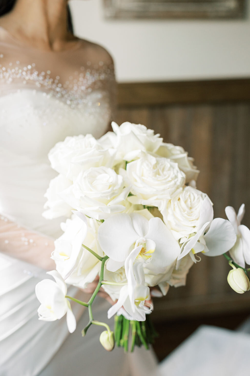 Bride poses with white flowers inside her Virginia barn wedding