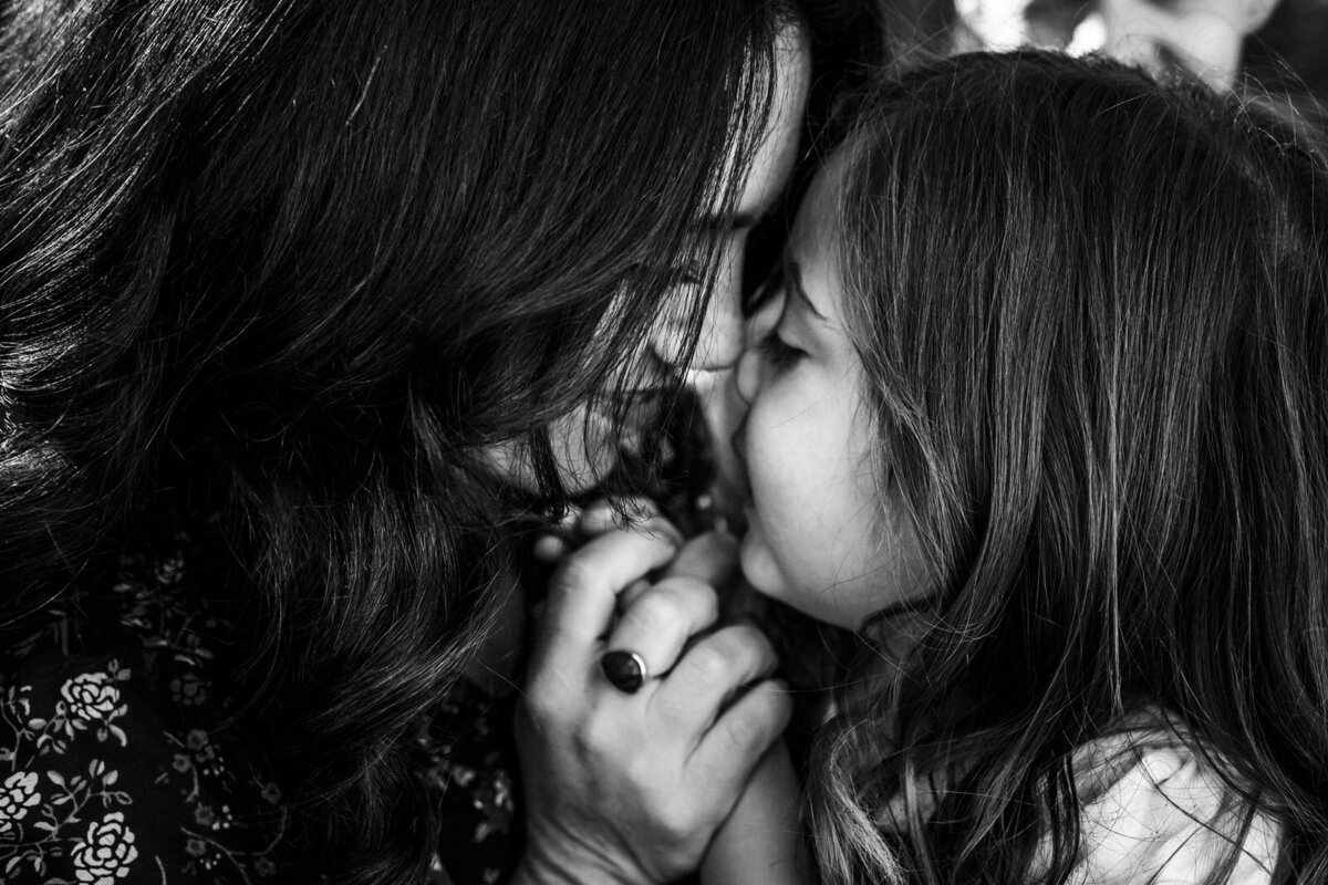 mom and 4-year-old daughter touching noses together and smiling at each other