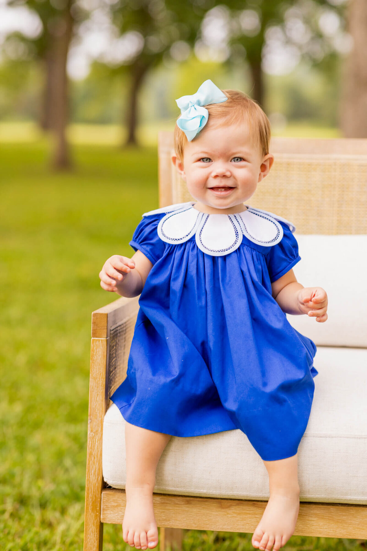 toddler girl sitting in a chair in a field