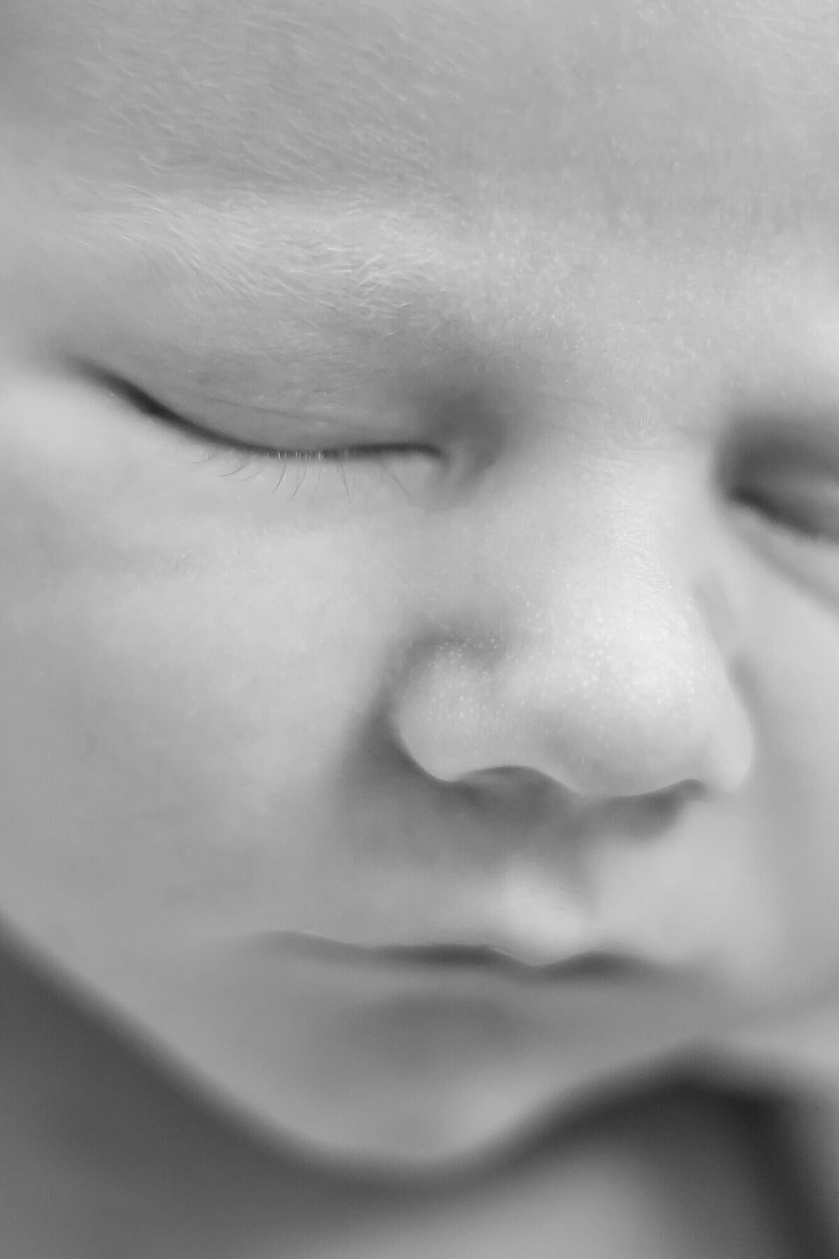 black and white close up of a newborn baby boy's nose and face