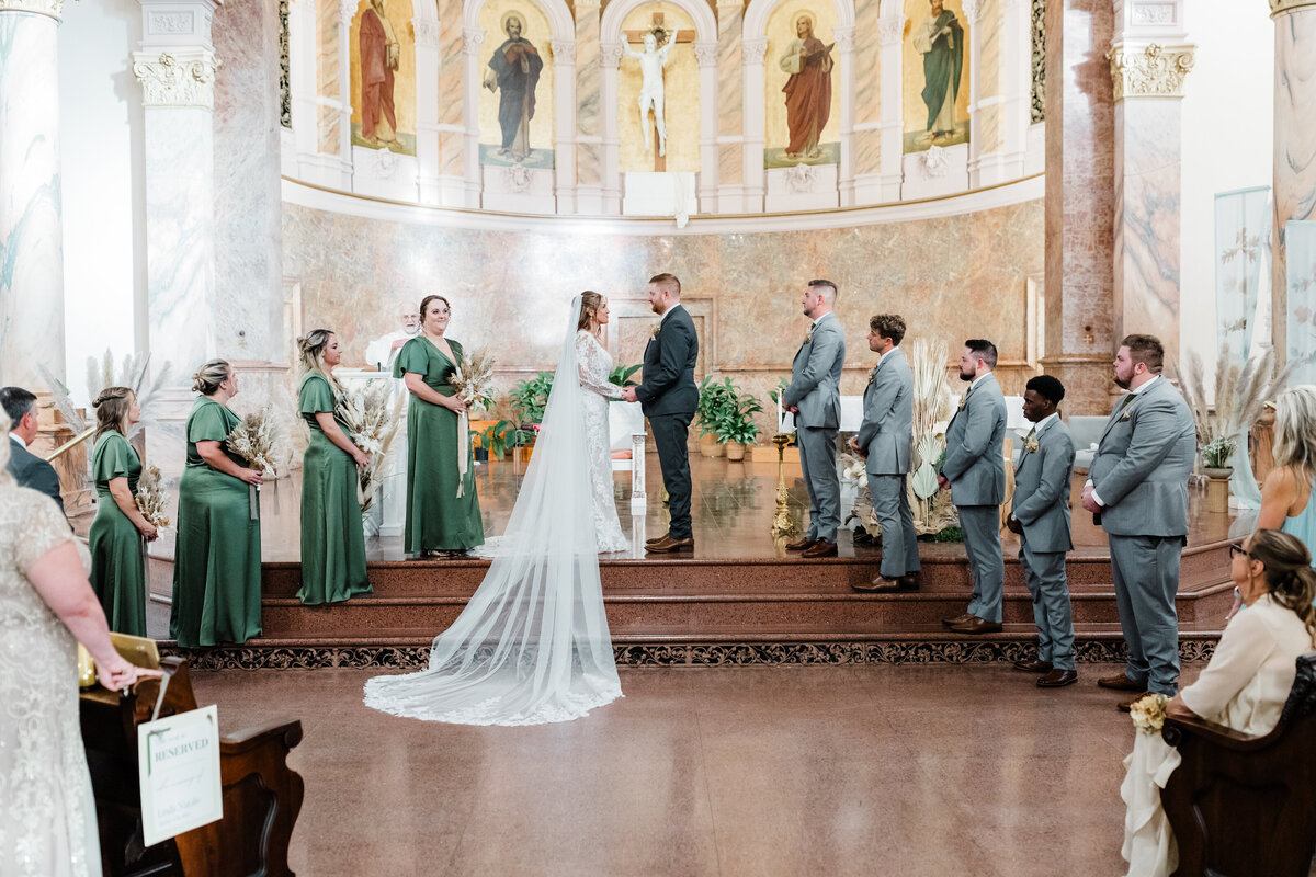 Bride walking down the aisle in a grand South Bend church during her wedding ceremony.