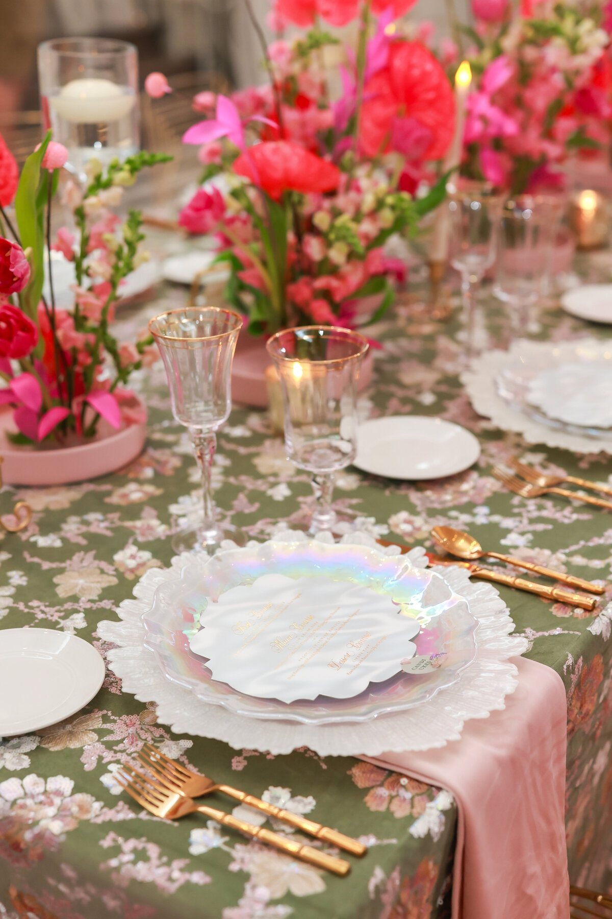 Vibrant tablescape featuring beautifully designed tablecloths, elegant china, colorful floral centerpieces, and glowing candles, creating a bold and sophisticated event setting