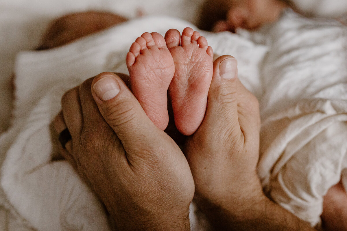 Dad holding newborn feet