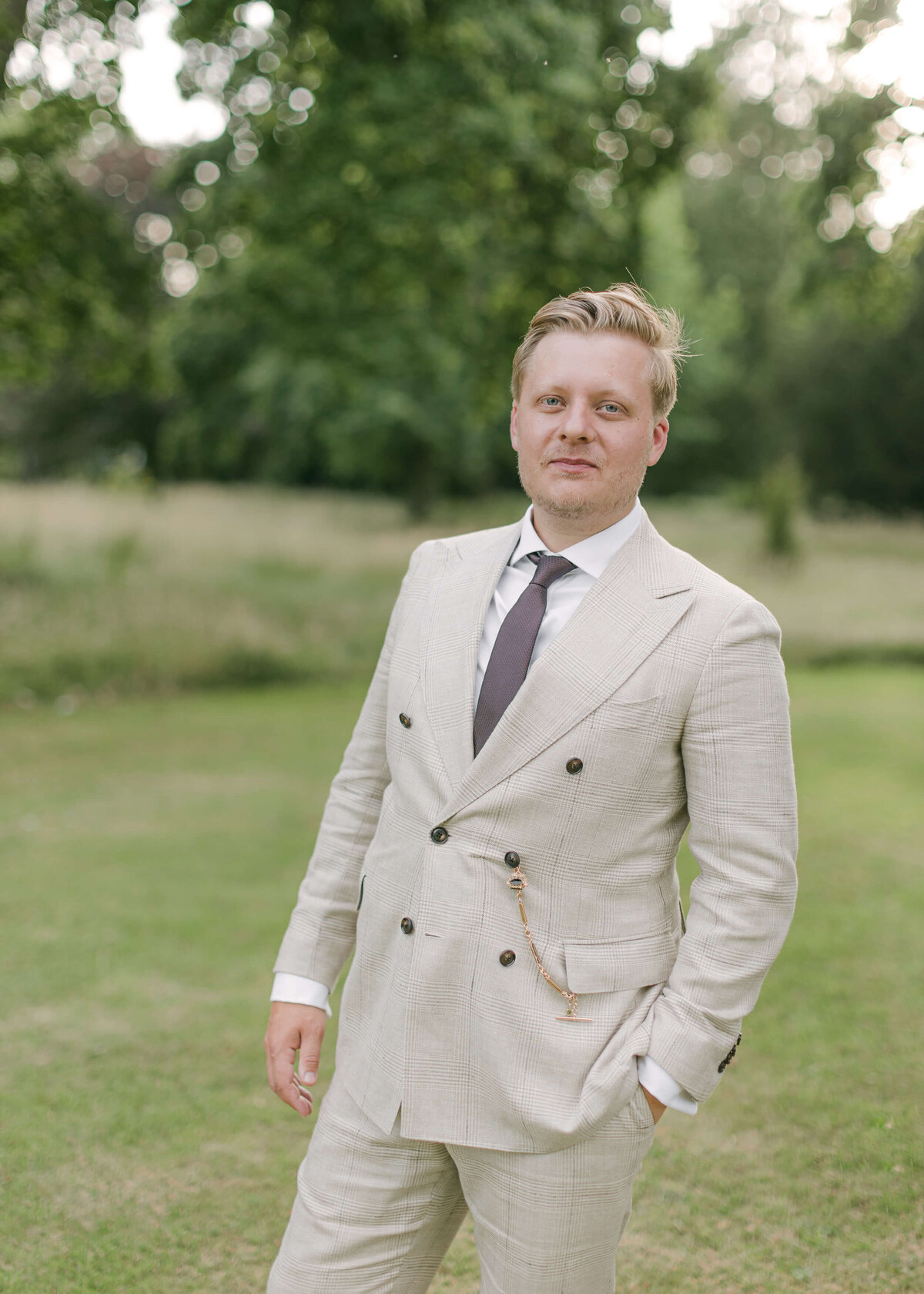 chloe-winstanley-weddings-grittleton-house-groom-portrait-grey-suit