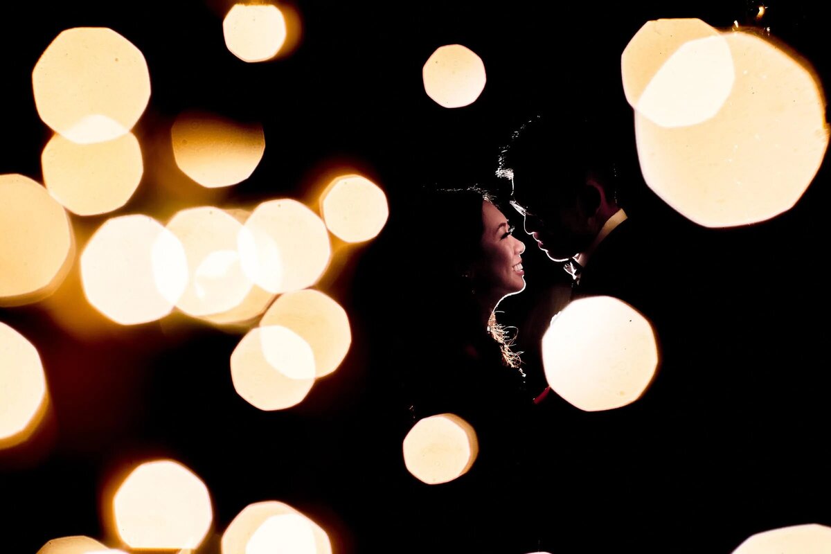 A couple is silhouetted against an array of beautiful bokeh lights