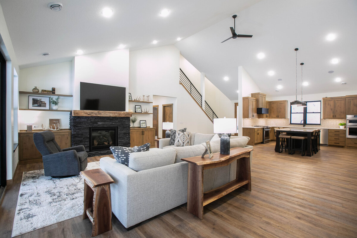 Cozy living room in Elk River custom home with fireplace, built-ins, and large windows