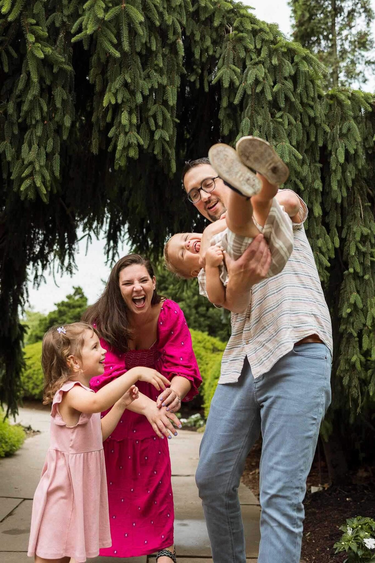 Family laughing and playing at Cleveland Botanical Gardens. Capturing natural moments of family connections.