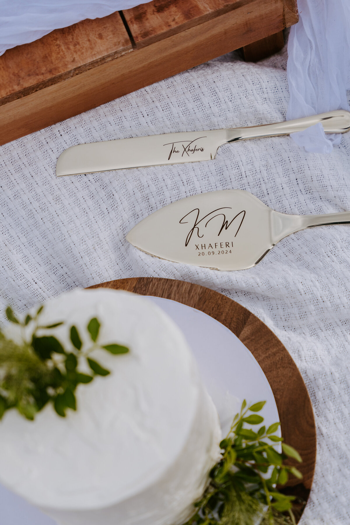 Engraved wedding cake knife and server on picnic setup.