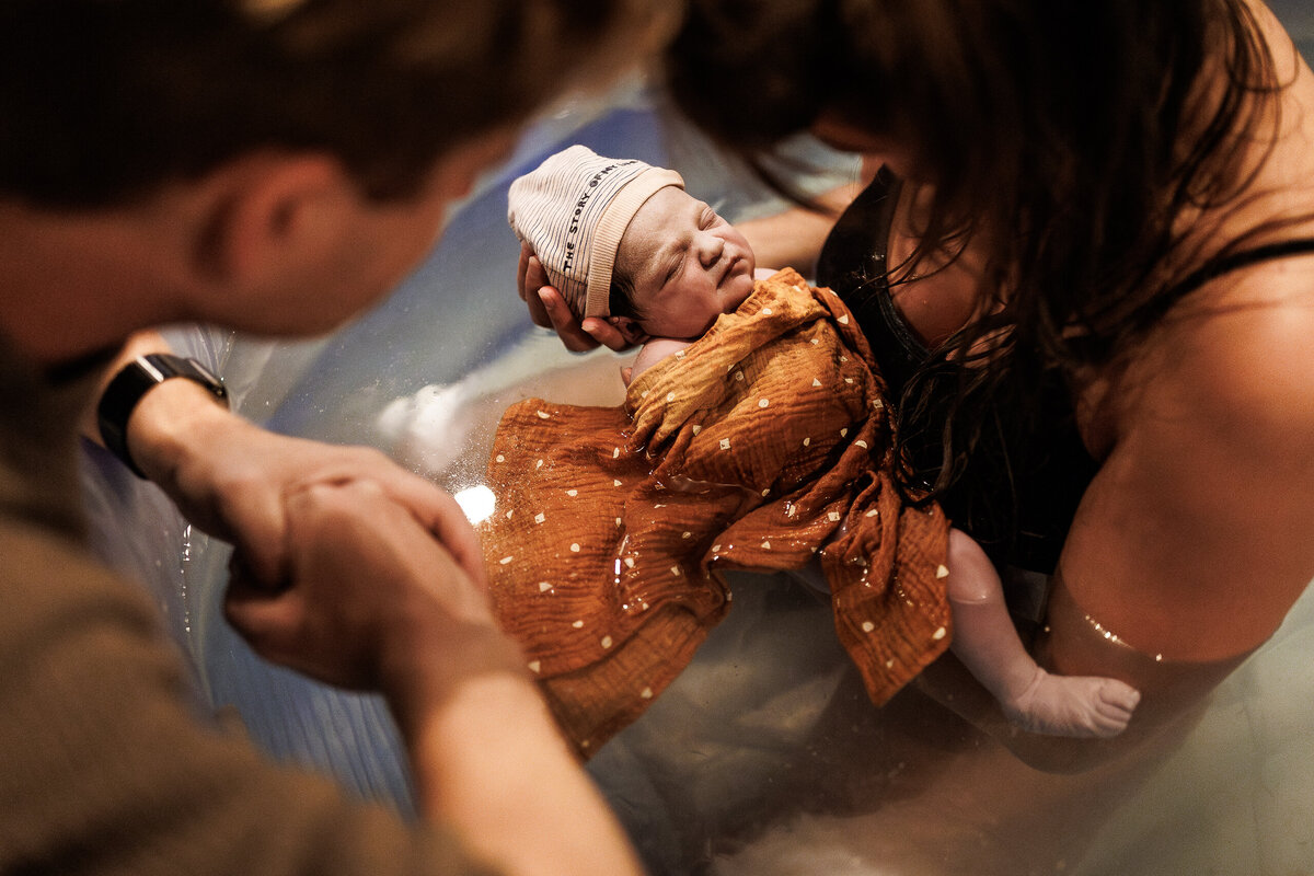 vader kijkt verwonderd naar zijn baby