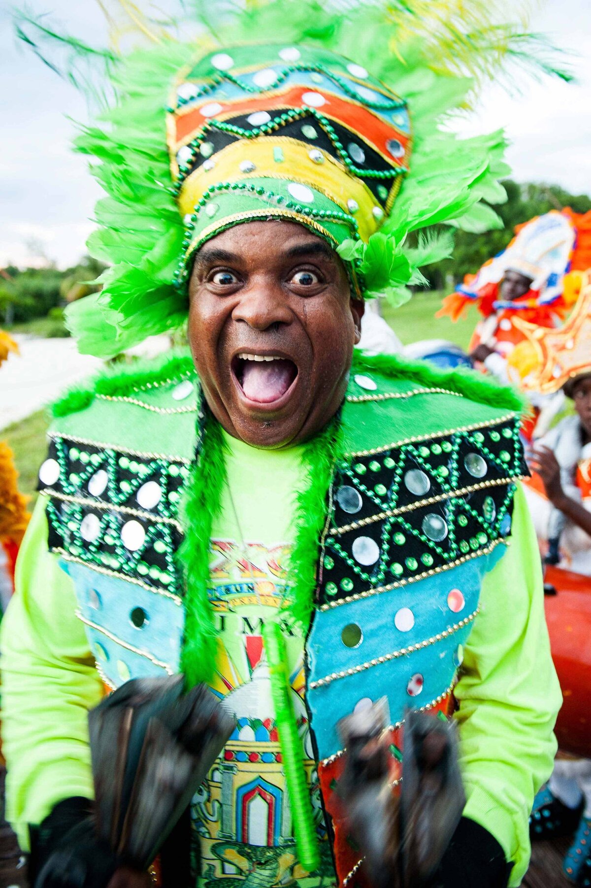 A man dressed in an ornate  Junkanoo outfit dances and sings at celebration. Harbour Island Bahamas