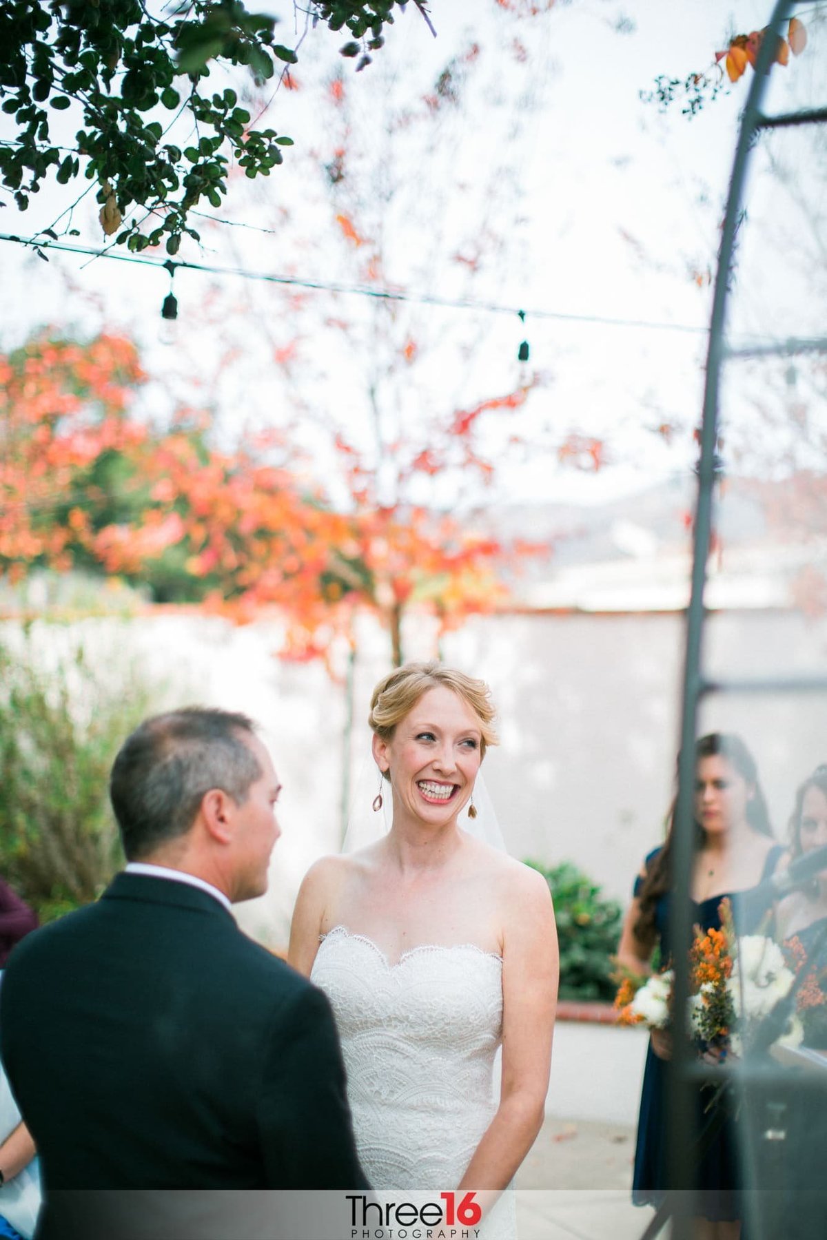 Bride turns to her wedding guests and flashes a big smile from the altar