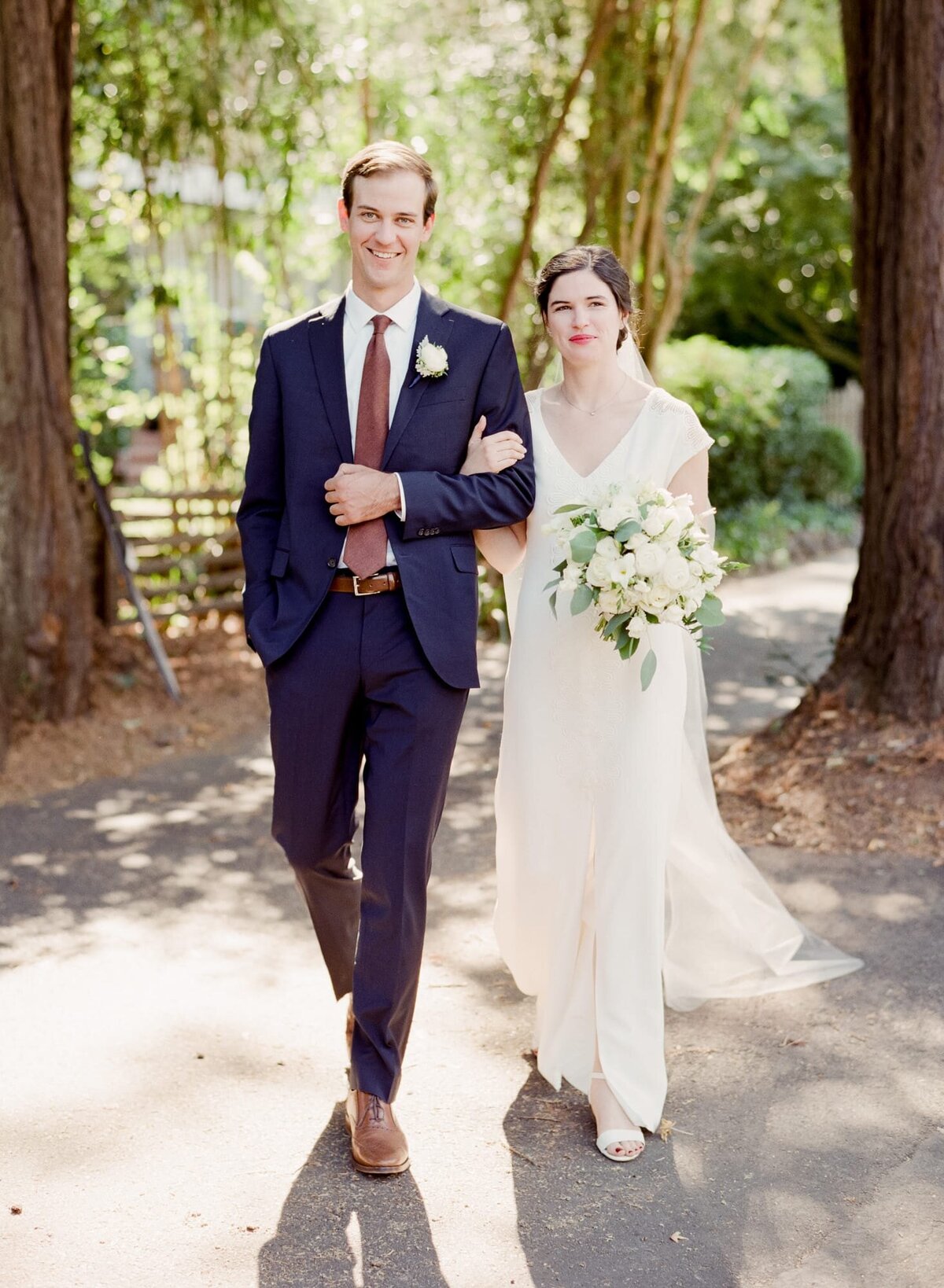 A proud groom walks his wife through the woods after an impressive forest wedding.