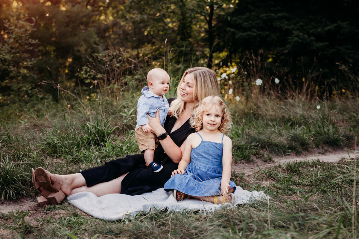 Mom with her two children on a blanket during family portraits in Toronto Park