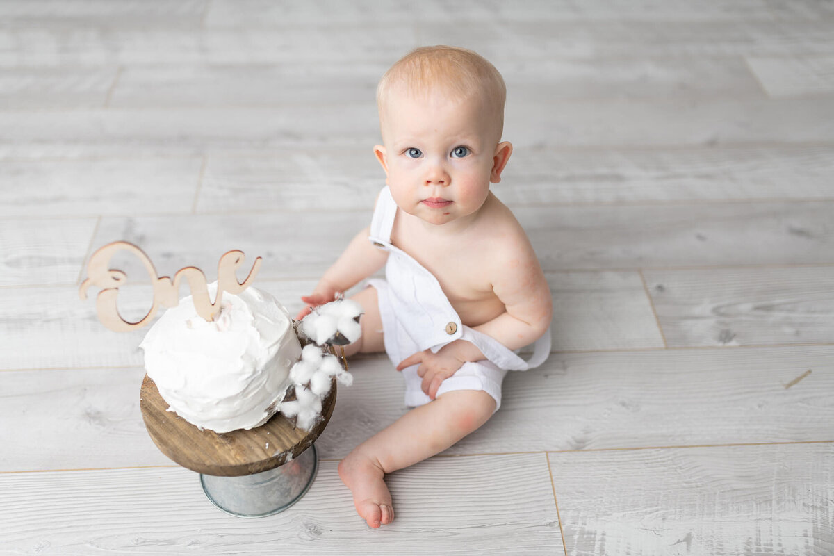 boy sitting with is smash cake