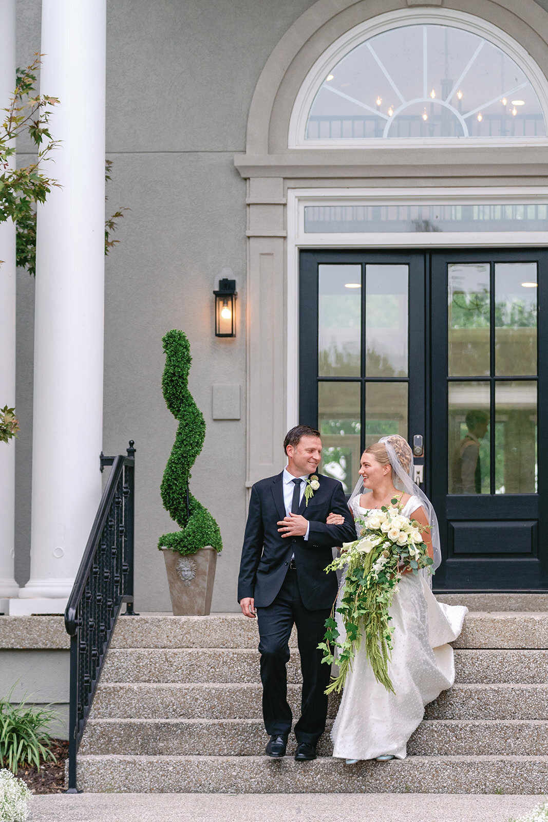 Bride walking down the steps to her outdoor wedding