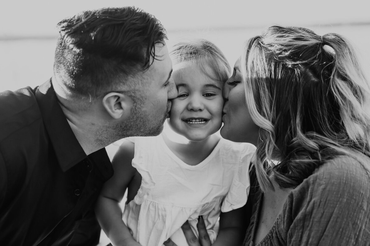 mom and dad kissing daughters cheeks in Atlanta Georgia  by family photographer Amanda Richardson Photography