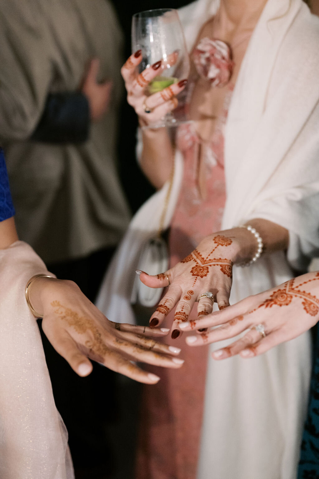 Guests show off fresh henna designs at the welcome celebration during a Highlands, NC wedding weekend.