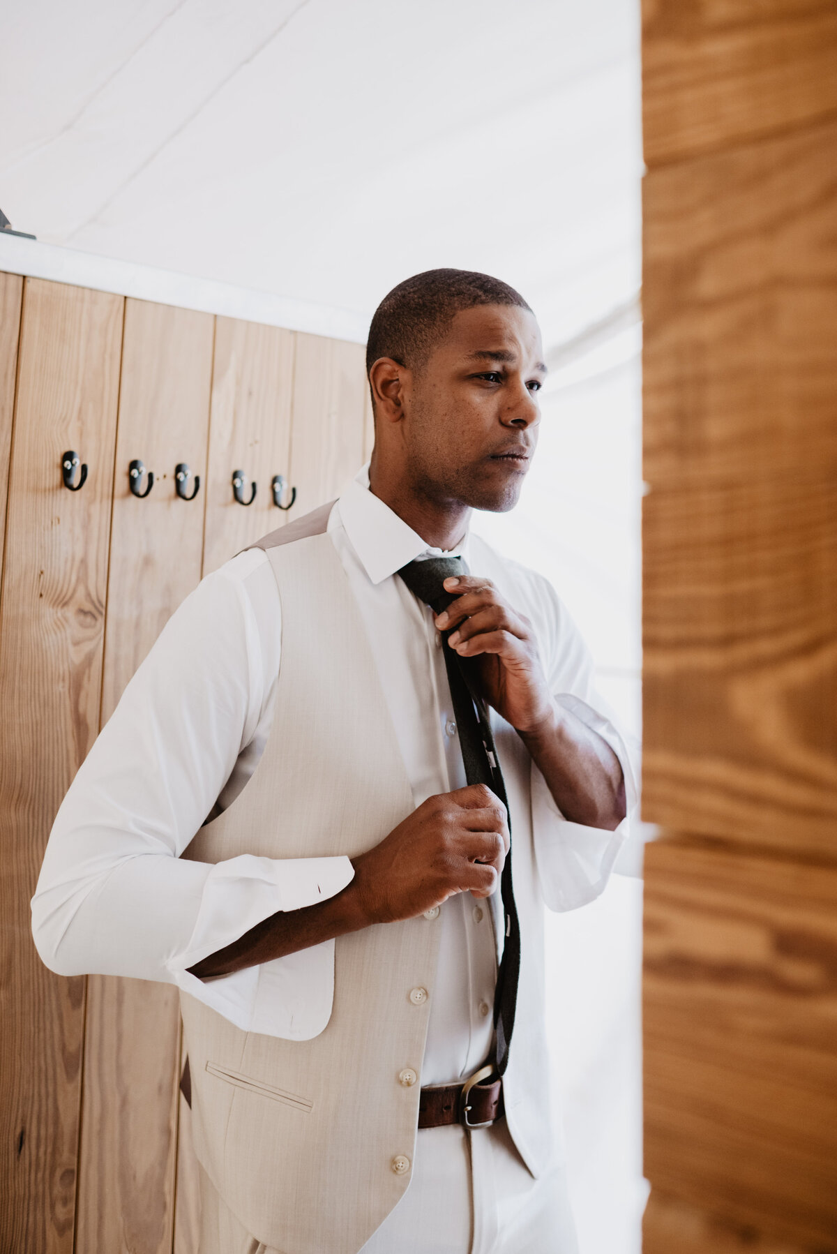 Utah Elopement Photographer captures groom getting ready putting on black tie