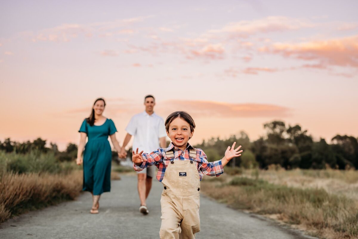 silly toddler runs towards the camera
