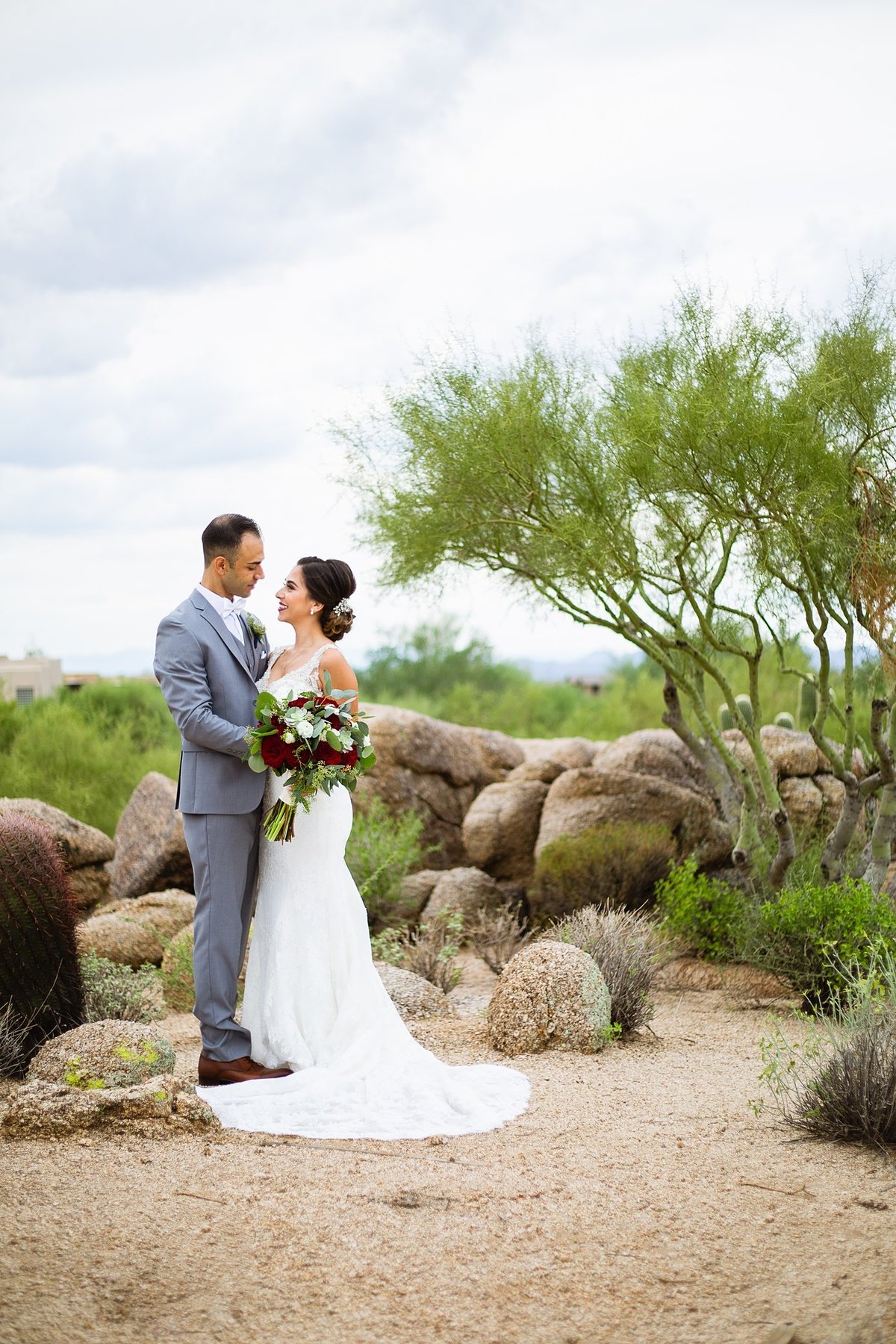 Bride and groom looking at each other in the Arizona desert by PMA Photography.