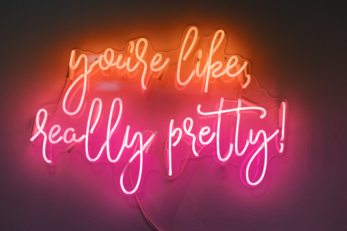 Bright pink neon sign reading “you’re like really pretty!” displayed at Brendan and Sara’s Fetewell wedding reception.