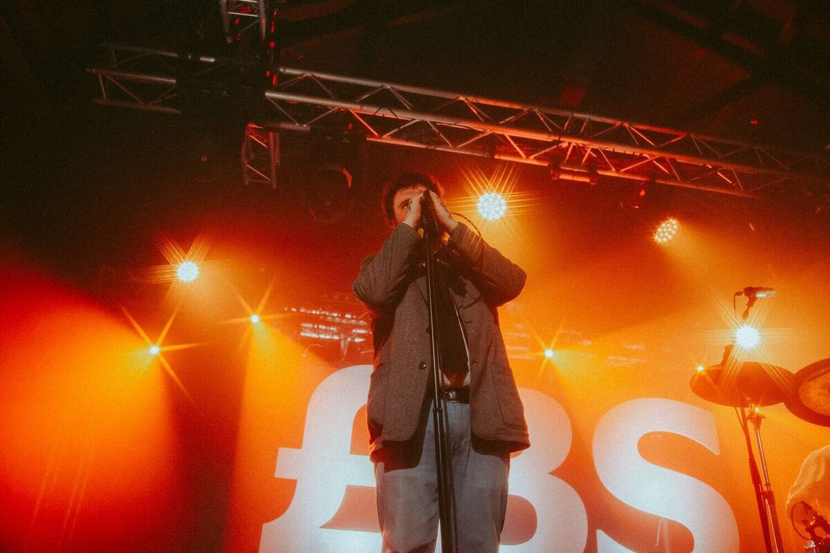 Big Special lead singer uses two hands to hold mic whilst singing on stage