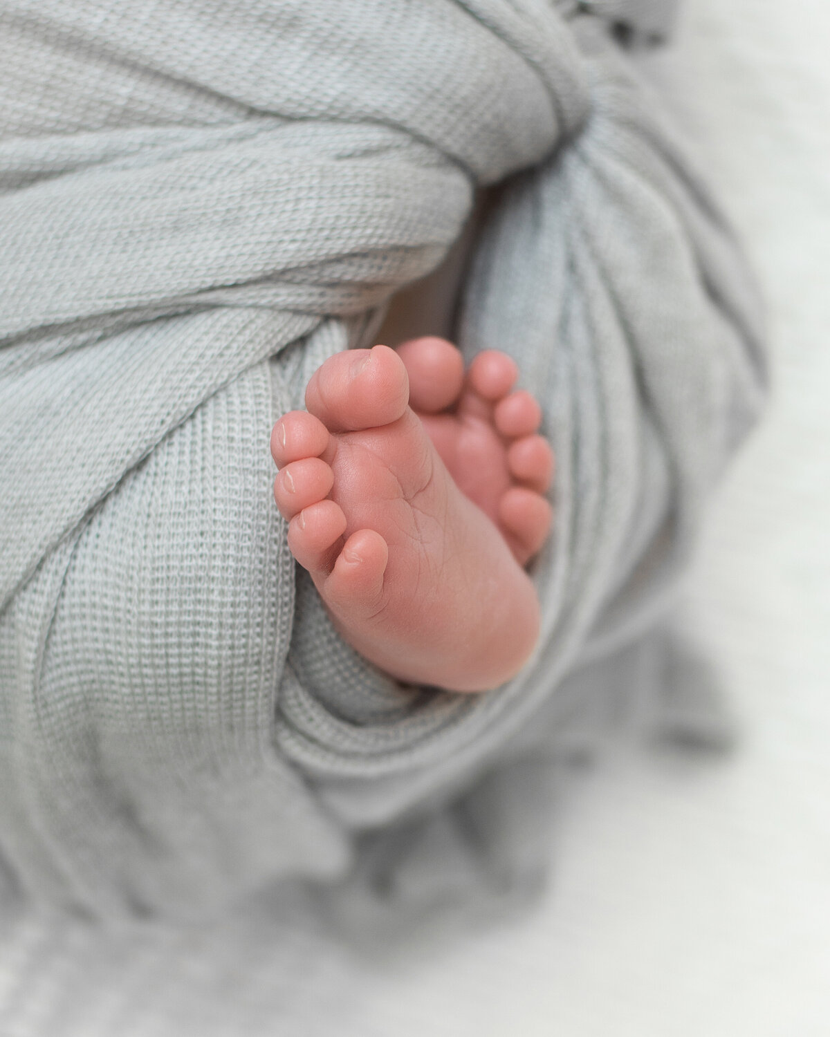 Close up photo of a newborn babies toes and feet