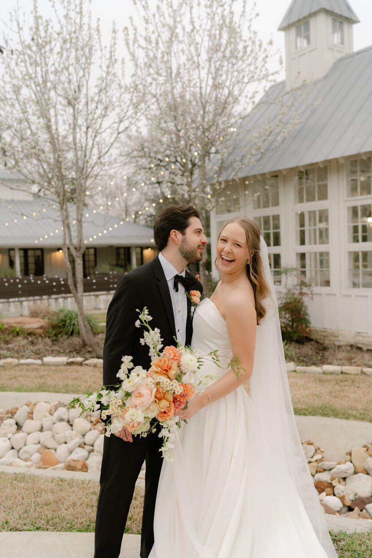 bride smiling at camera while groom laughs