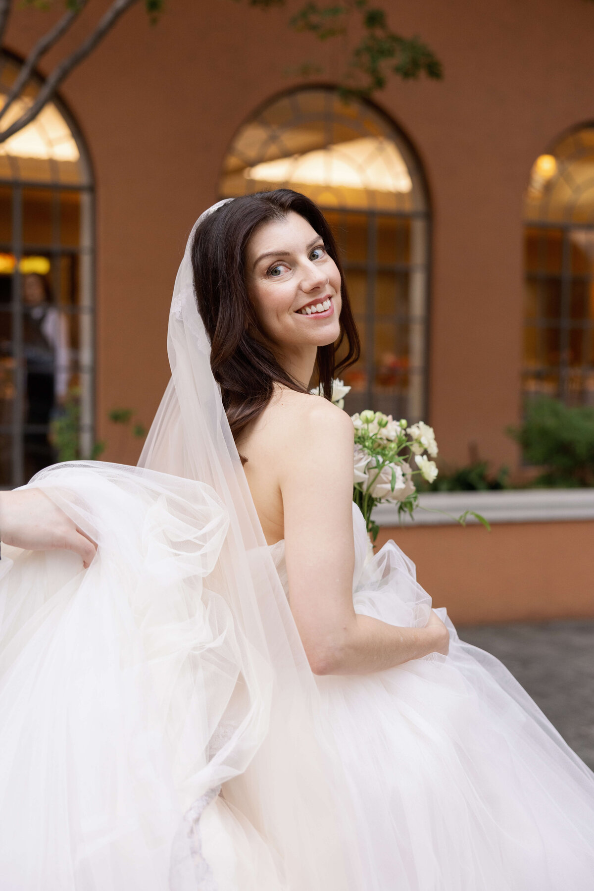 Bride posing outside of at Rosewood Mansion on Turtle Creek before her wedding, wearing a tulle gown