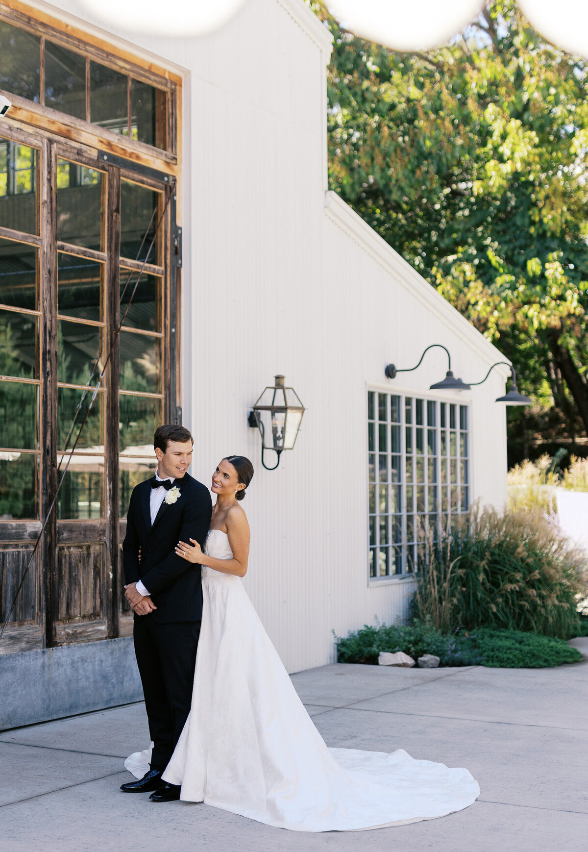 Bride hugging her husband from behind as they stand in front of the Quarry wedding venue in Knoxville TN