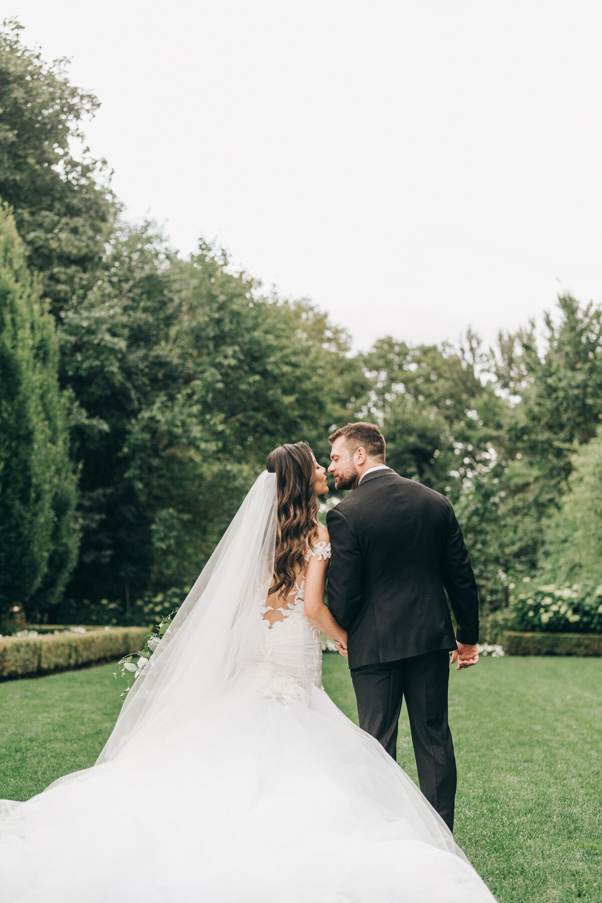 Glamorous bride and groom kissing during wedding portraits