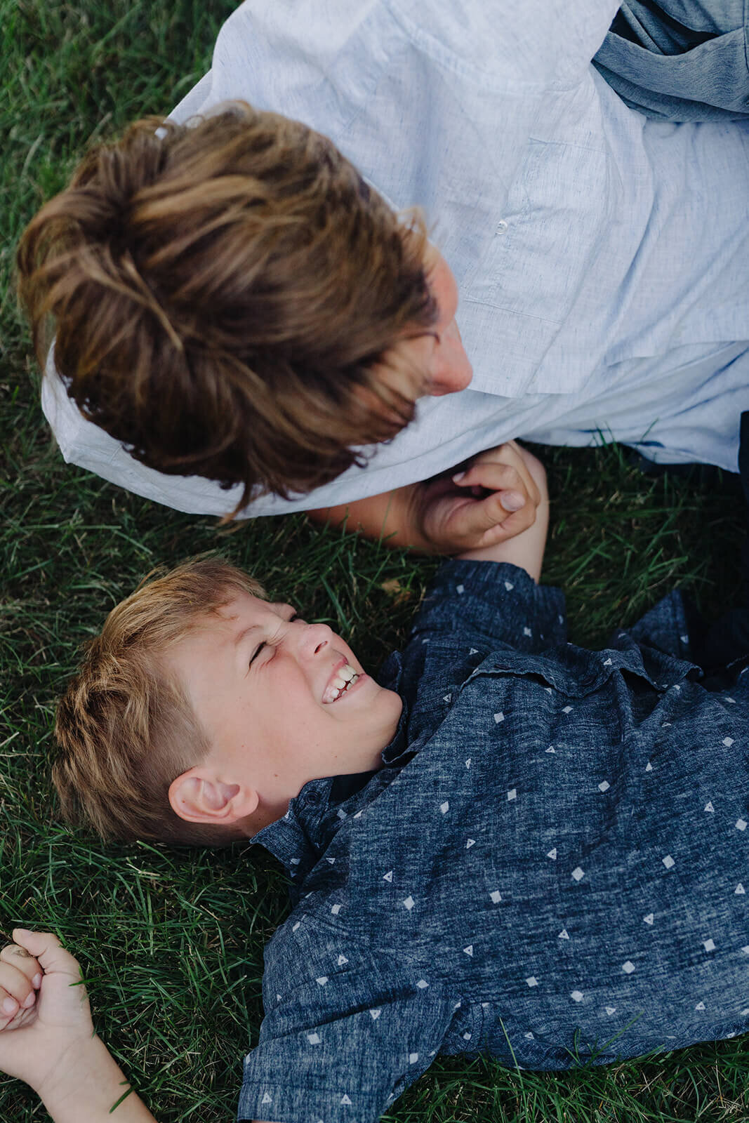 boy lying on the grass laughing at generational photoshoot in Finger Lakes, NY
