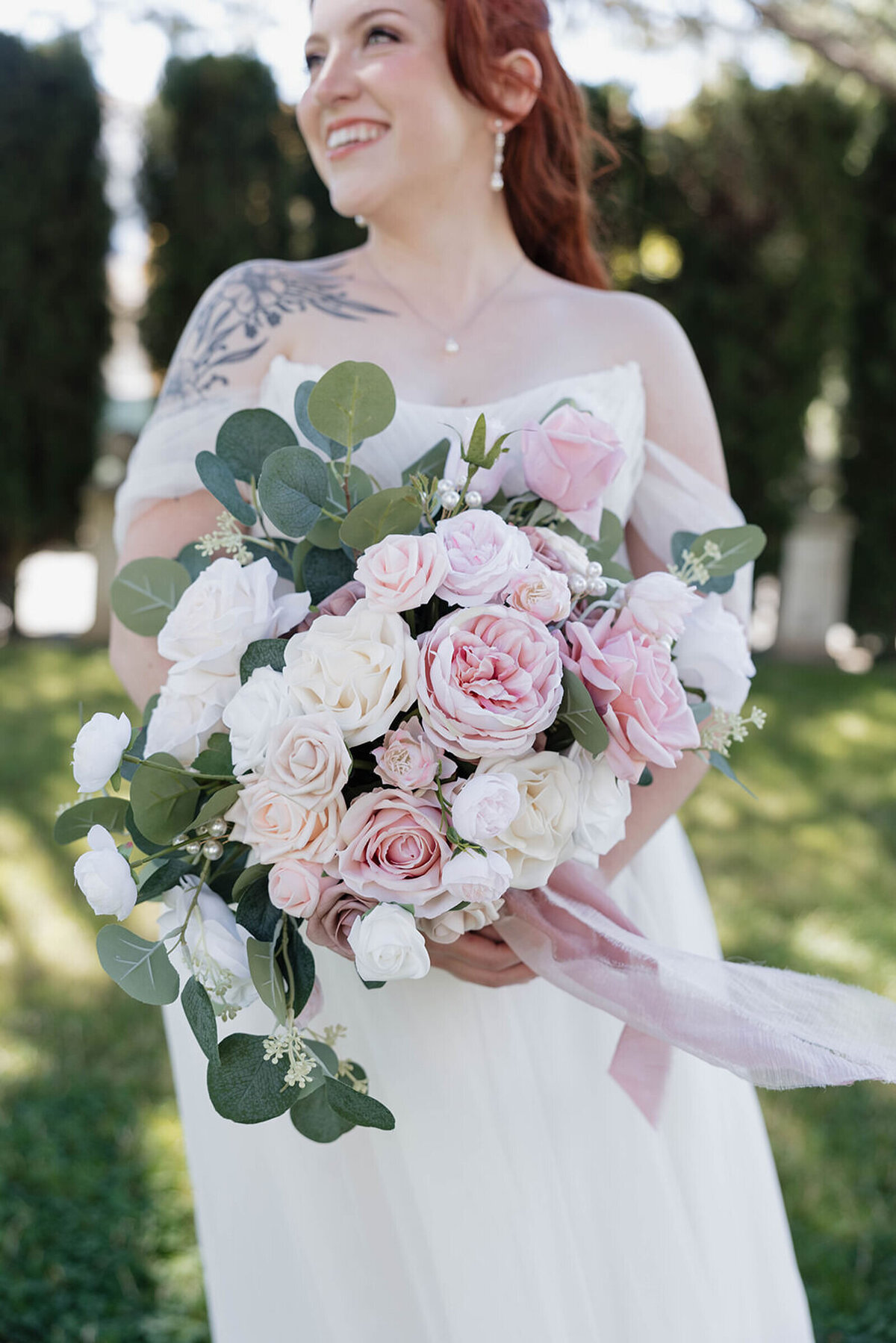 Bride laughing with her pink rose bouquet