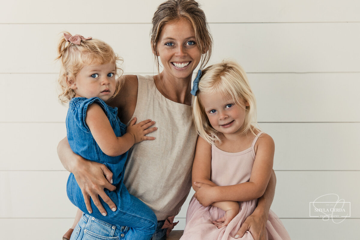 Mom smiling at camera with two daughters