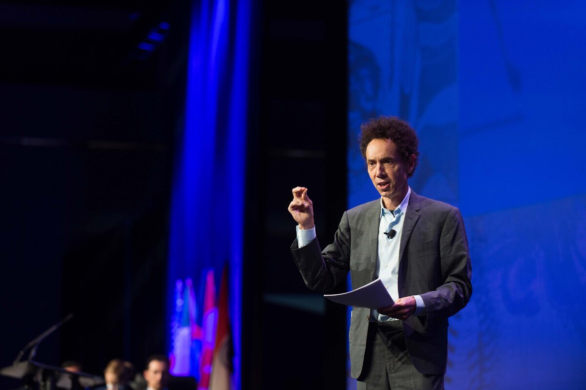 Malcolm Gladwell guest speaks at an annual meeting in Austin TX convention center while onstage