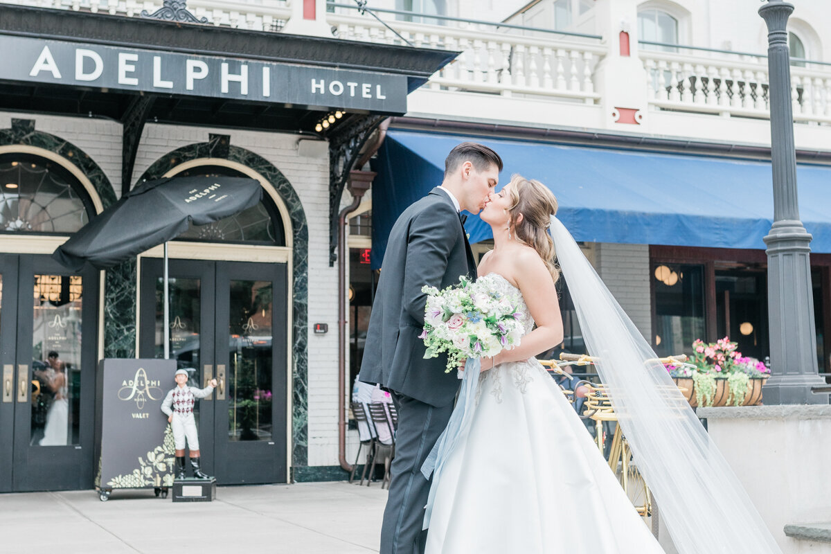 Bride and groom kissing on their wedding day in front of the Adelphi hotel in Saratoga Springs, NY