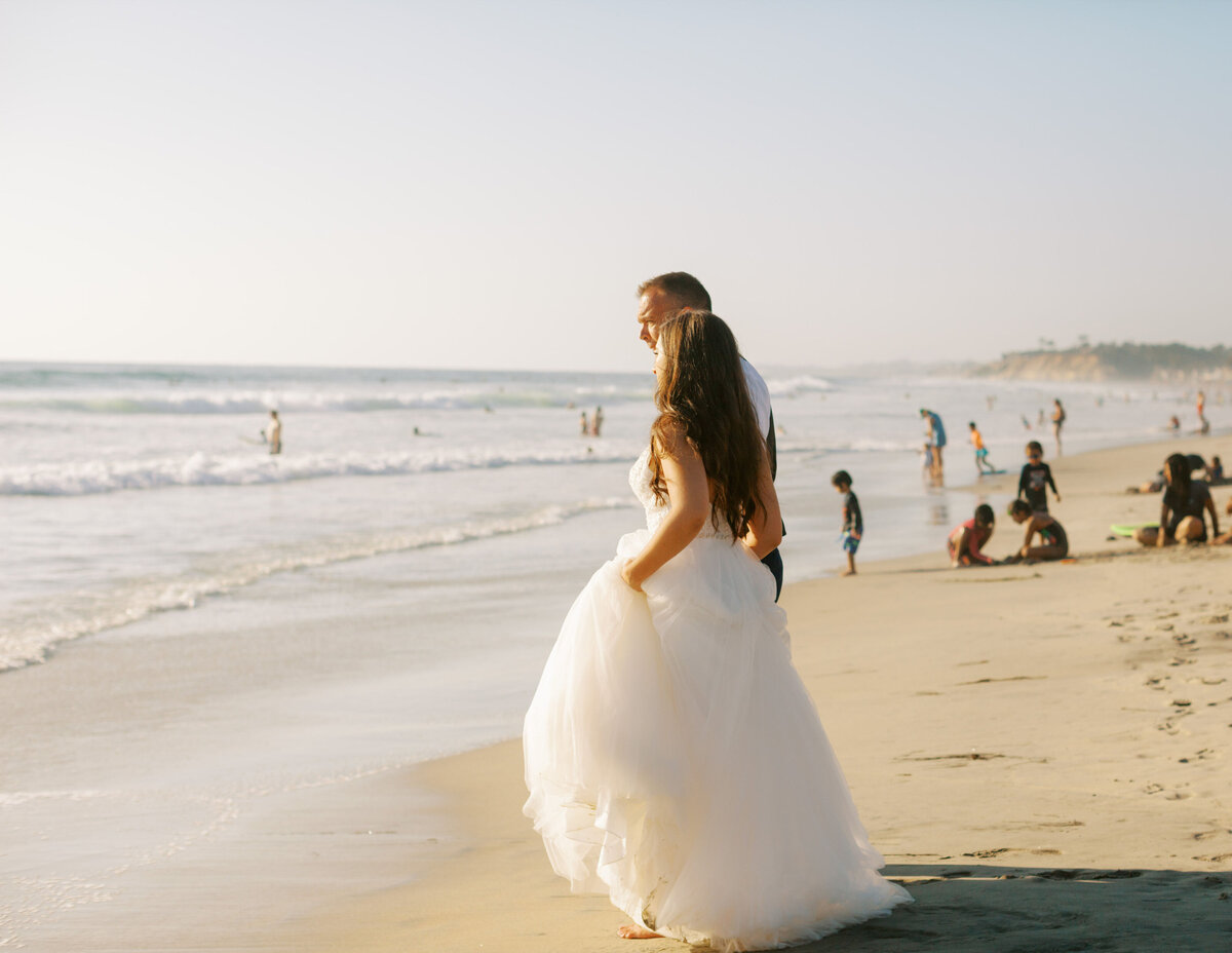 bride and groom looking oceanside in southern California