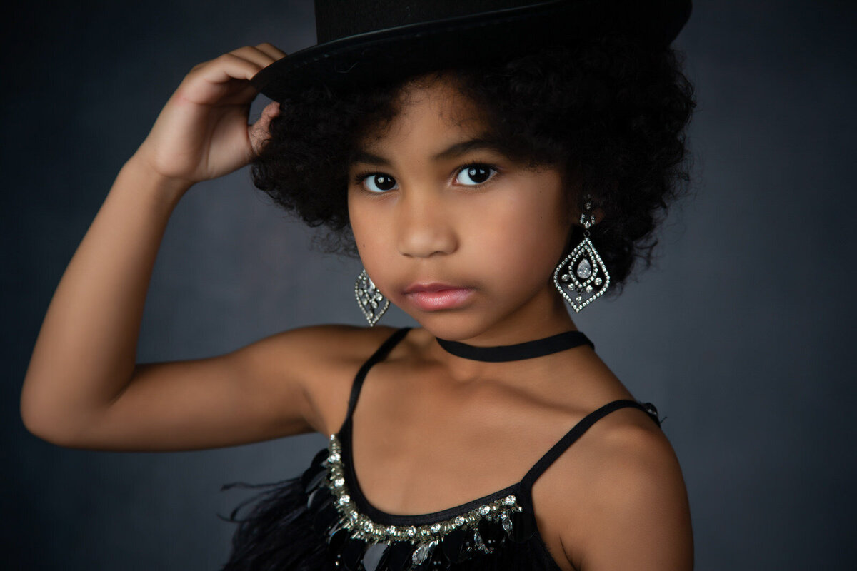 tween-in-studio-wearing-black-ttdm-dress-with-silver-accents-holding-black-hat-arlington-tx