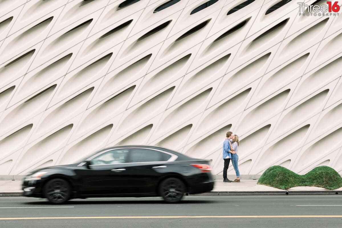Outside The Broad engaged couple share a kiss as cars drive by
