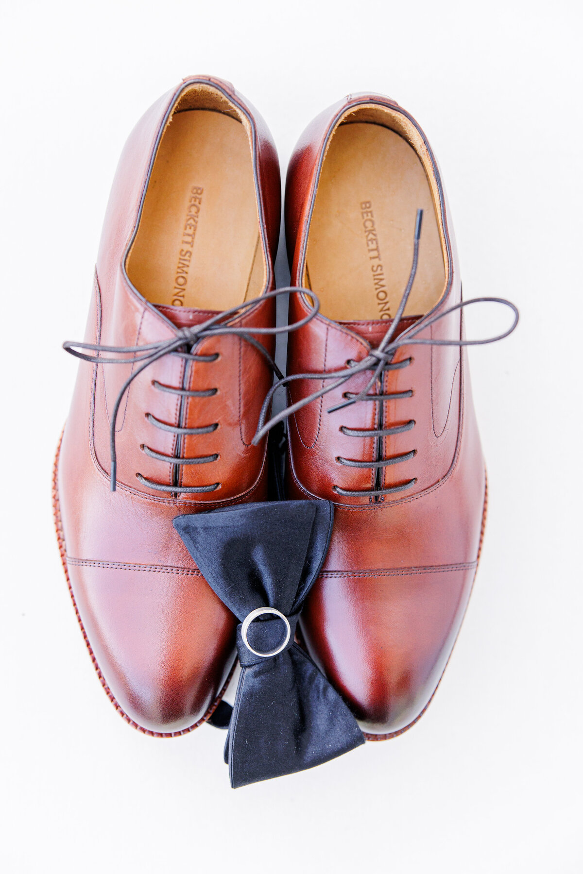 Groom's shoes with a bow tie and wedding band on top representing Boston wedding details