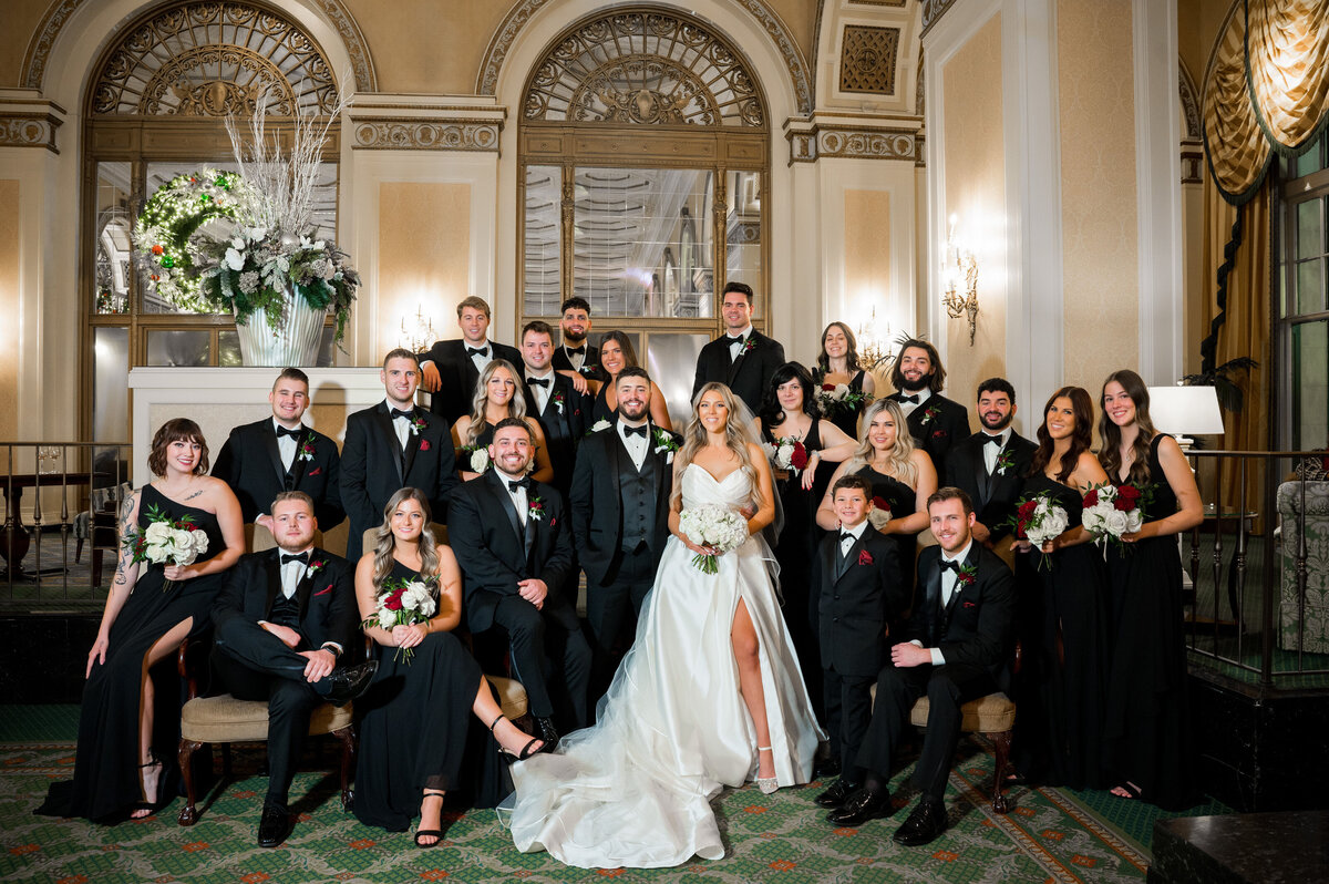 wedding party posing for photos at omni william penn lobby