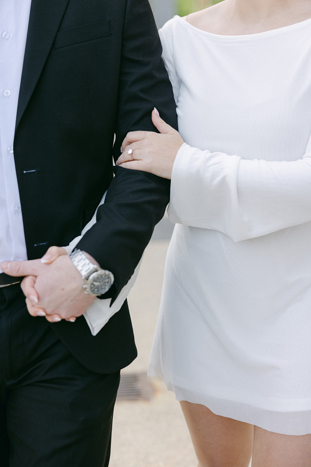 close up of an engaged couple with their arms linked
