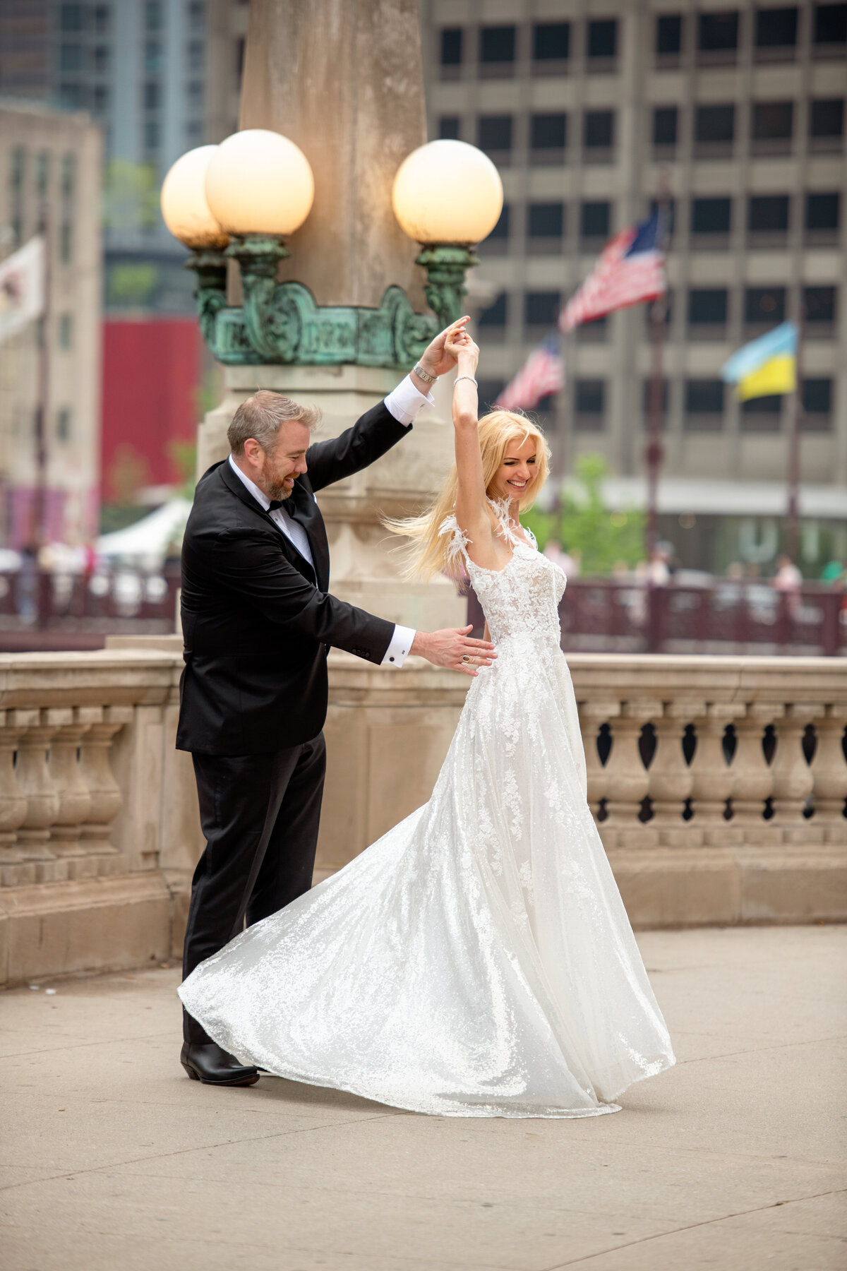 bride and groom spinning around  on the riverwalk sidewalk and dancing like no one is watching