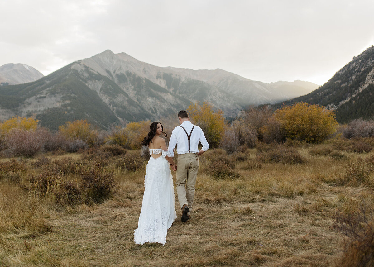 Married couple walking towards mountains
