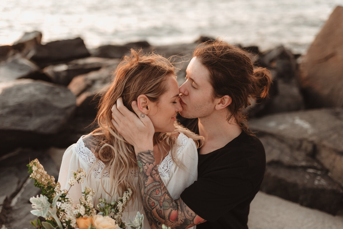 Couple sharing a kiss on the beach during a romantic photo session in Pennsylvania