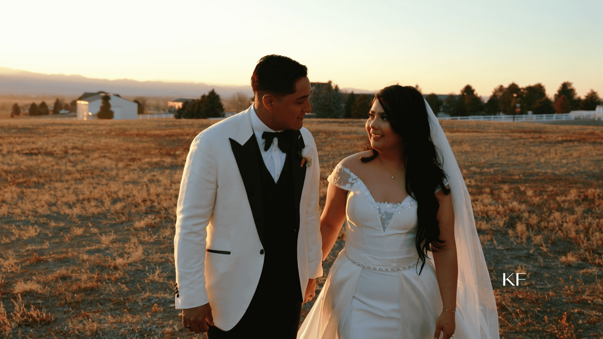 bride and groom walk outdoors at golden hour in the fall with mountains in the back