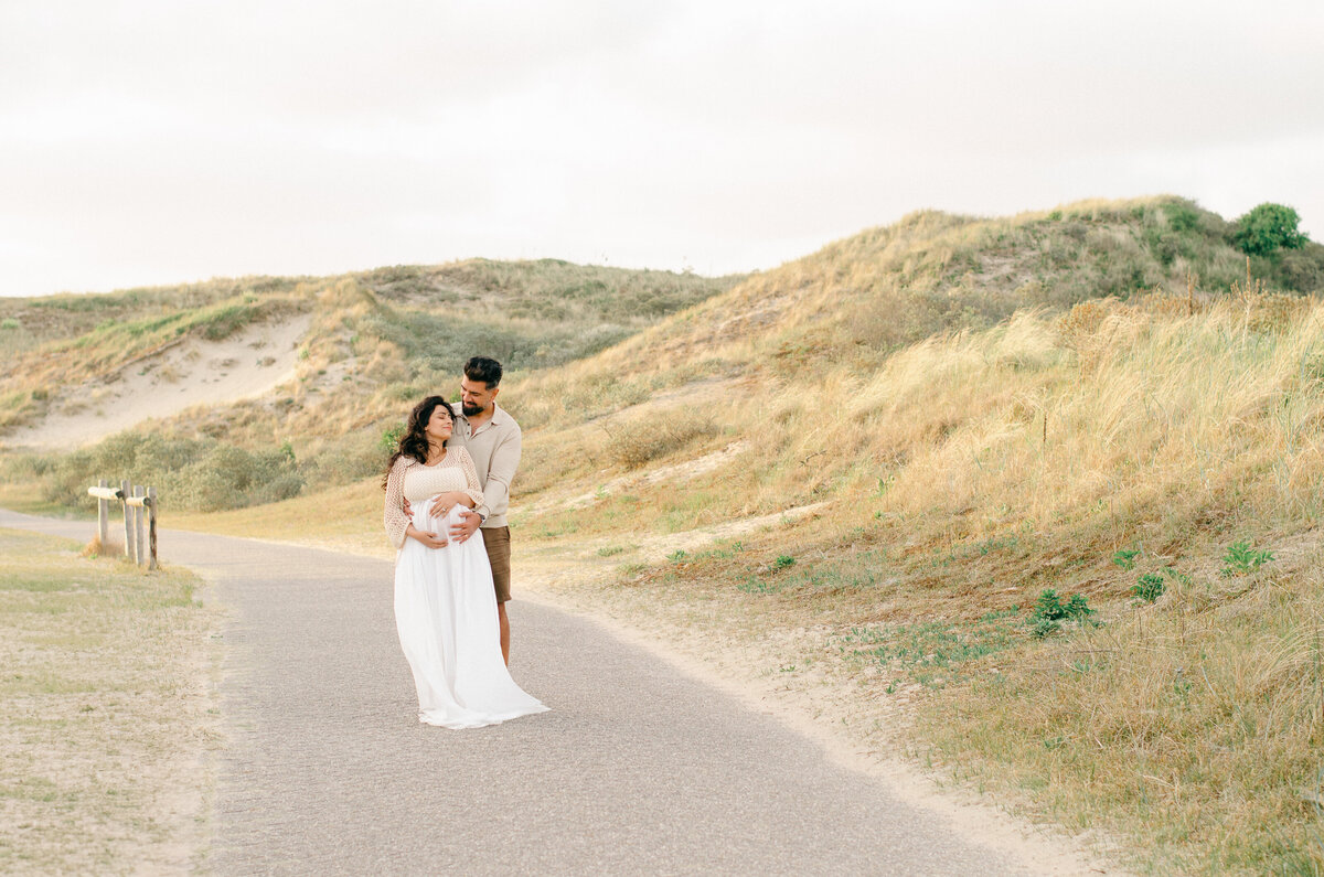 pregnant couple in the sand dunes in Bloemendaal, a beach with sand dunes near Amsterdam