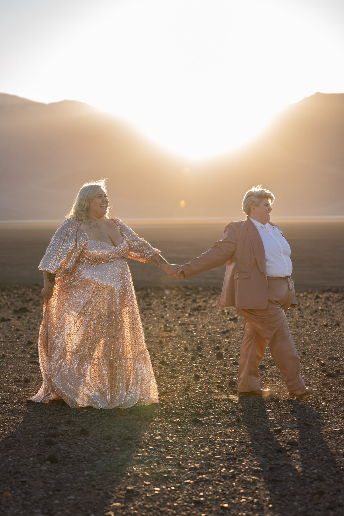 A couple holding hands and walking in the desert