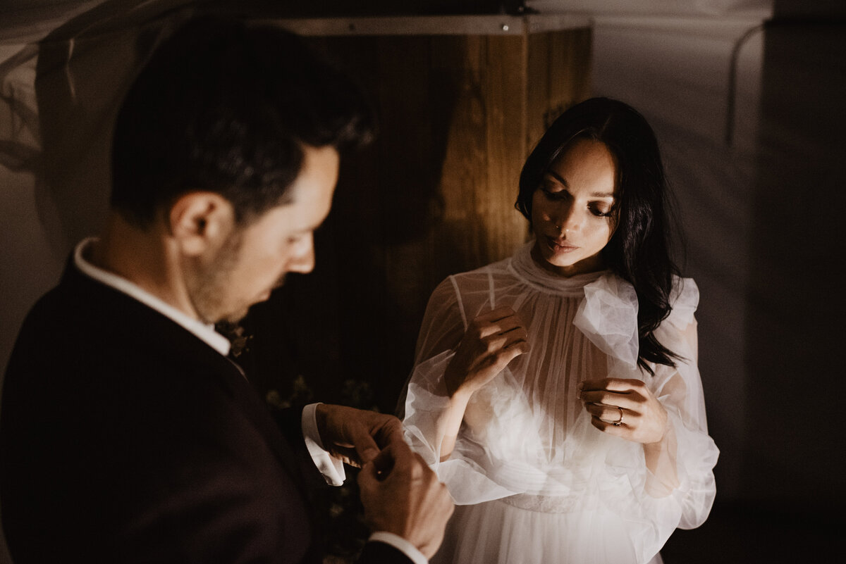 Utah elopement photographer captures bride and groom putting on jewelry before National Parks wedding