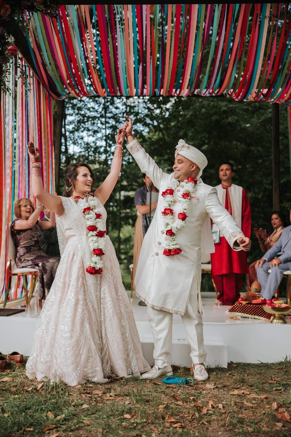 Happily married couple holding hands in excitement after breaking the glass in their Indian Jewish wedding.Happily married couple holding hands as they prepare to leave in excitement after breaking the glass in their Indian Jewish wedding ceremony.